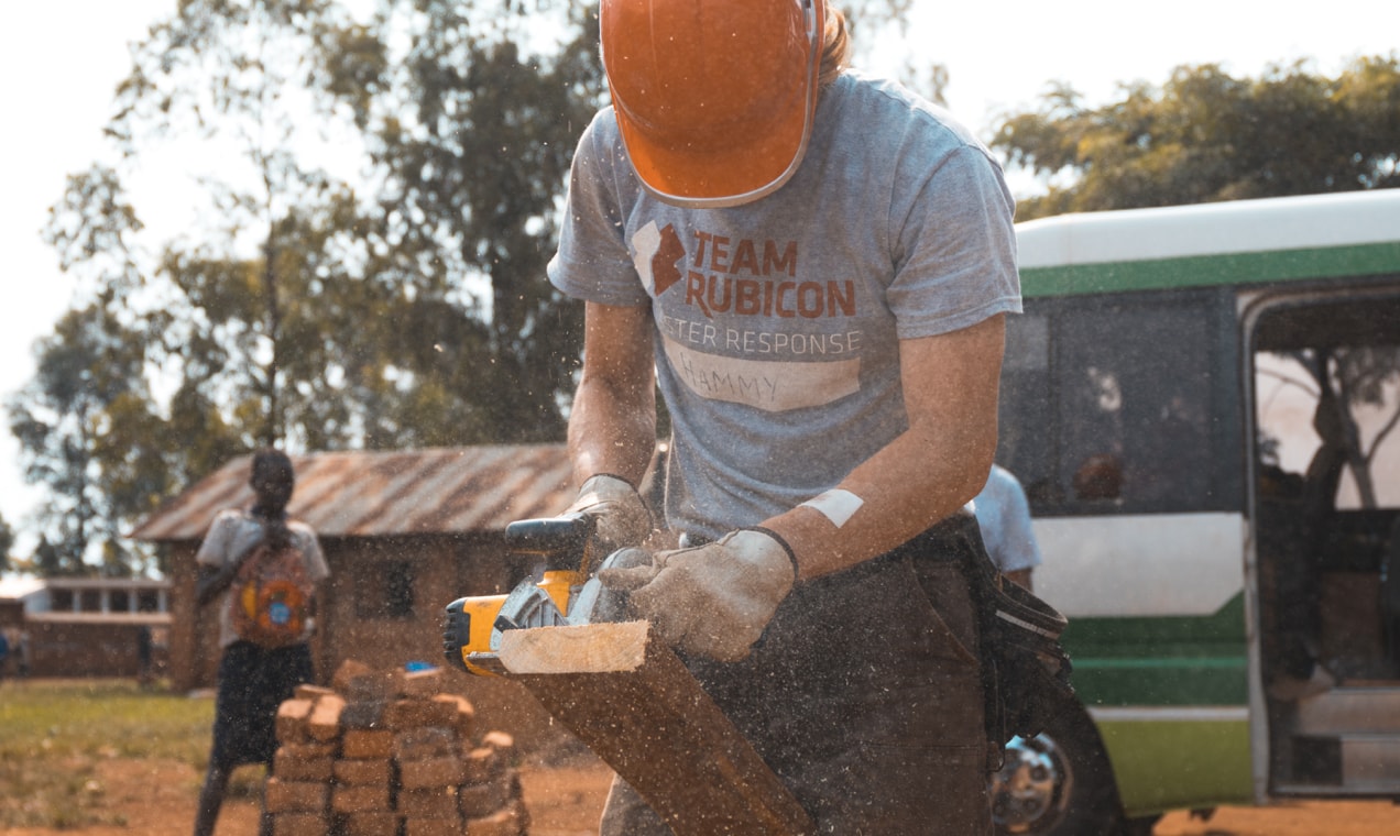 nonprofit volunteer sawing a board