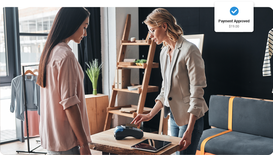 Women completing a card payment using FooSales WooCommerce Point of Sales and a card reader.