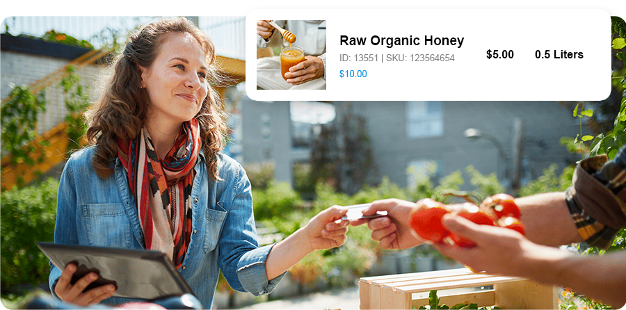 Women smiling at a food market while accepting payment