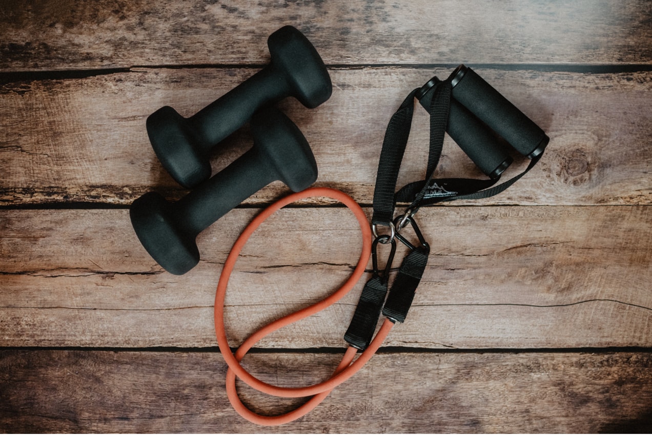 resistance band and weights on a wood floor