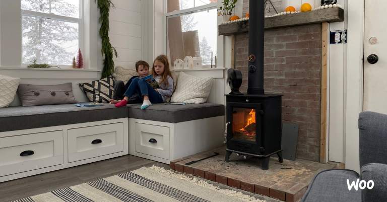 kids reading in front of a tiny wood stove