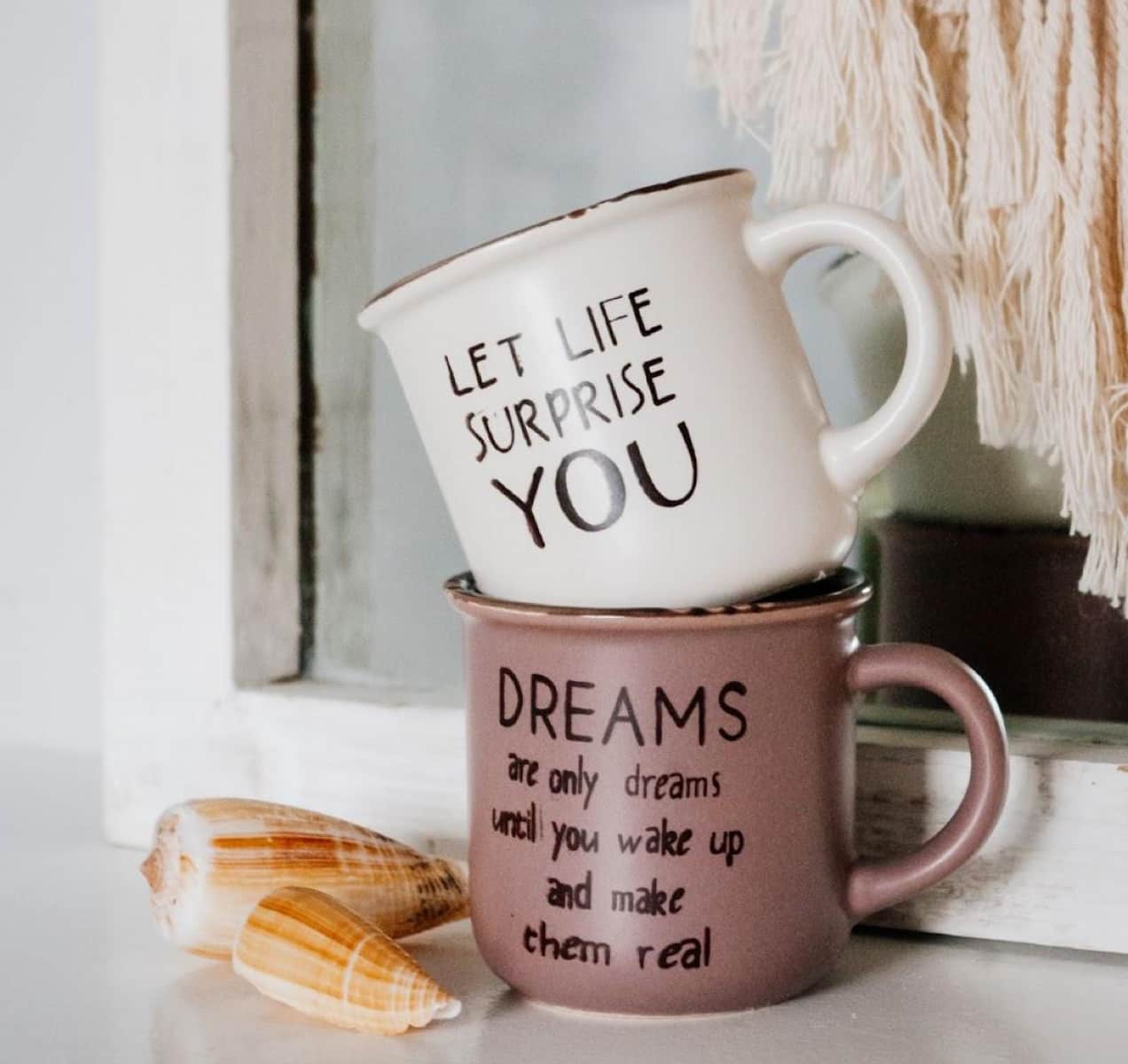 mugs with fun sayings stacked on a table
