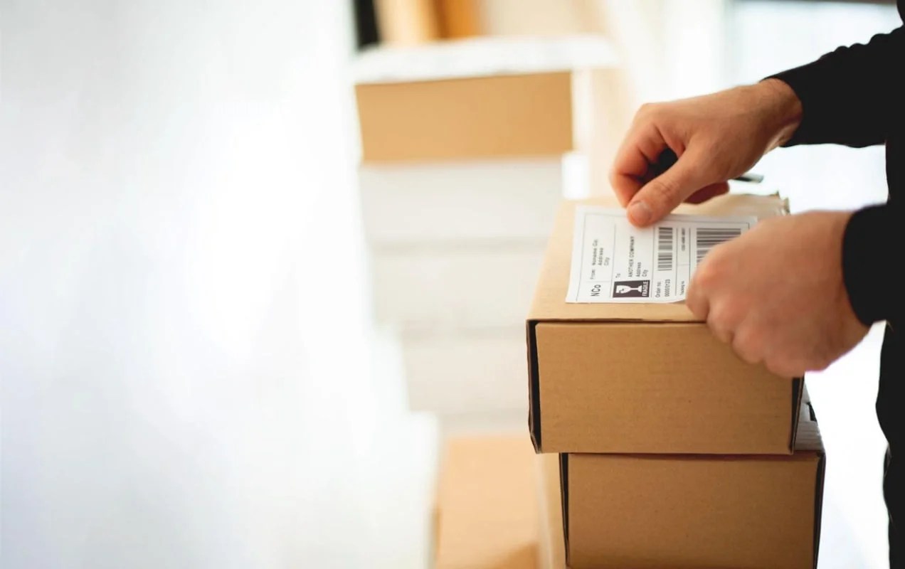 business owner applying a shipping label to a box