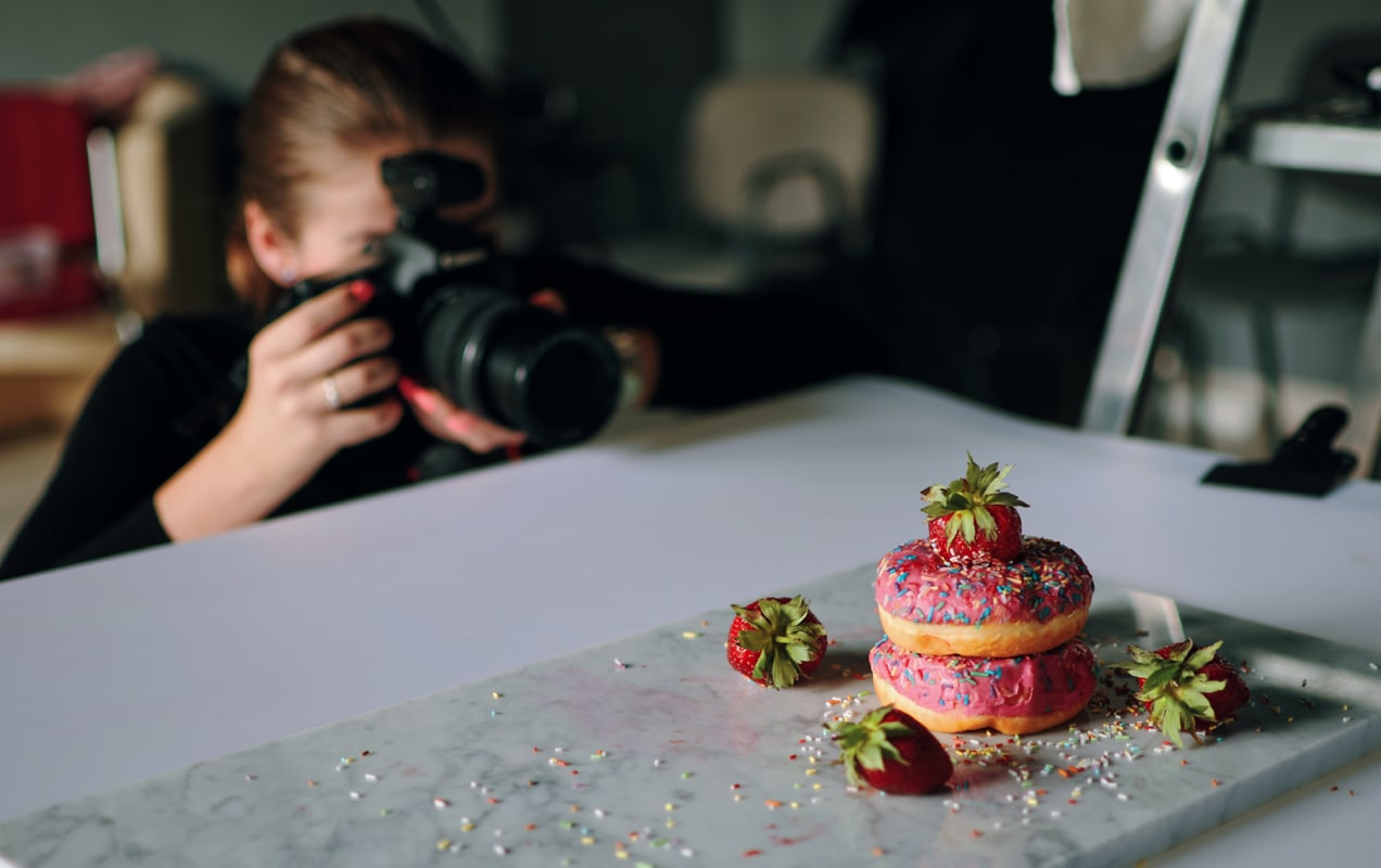 entrepreneur taking pictures of donuts with a DSLR camera