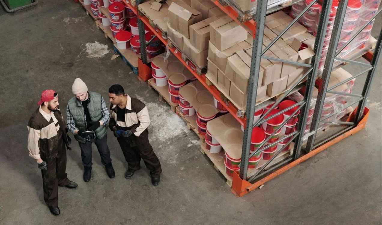 three men reviewing a tablet in a warehouse