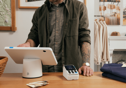Merchant taking a payment at the counter with a PayPal POS terminal
