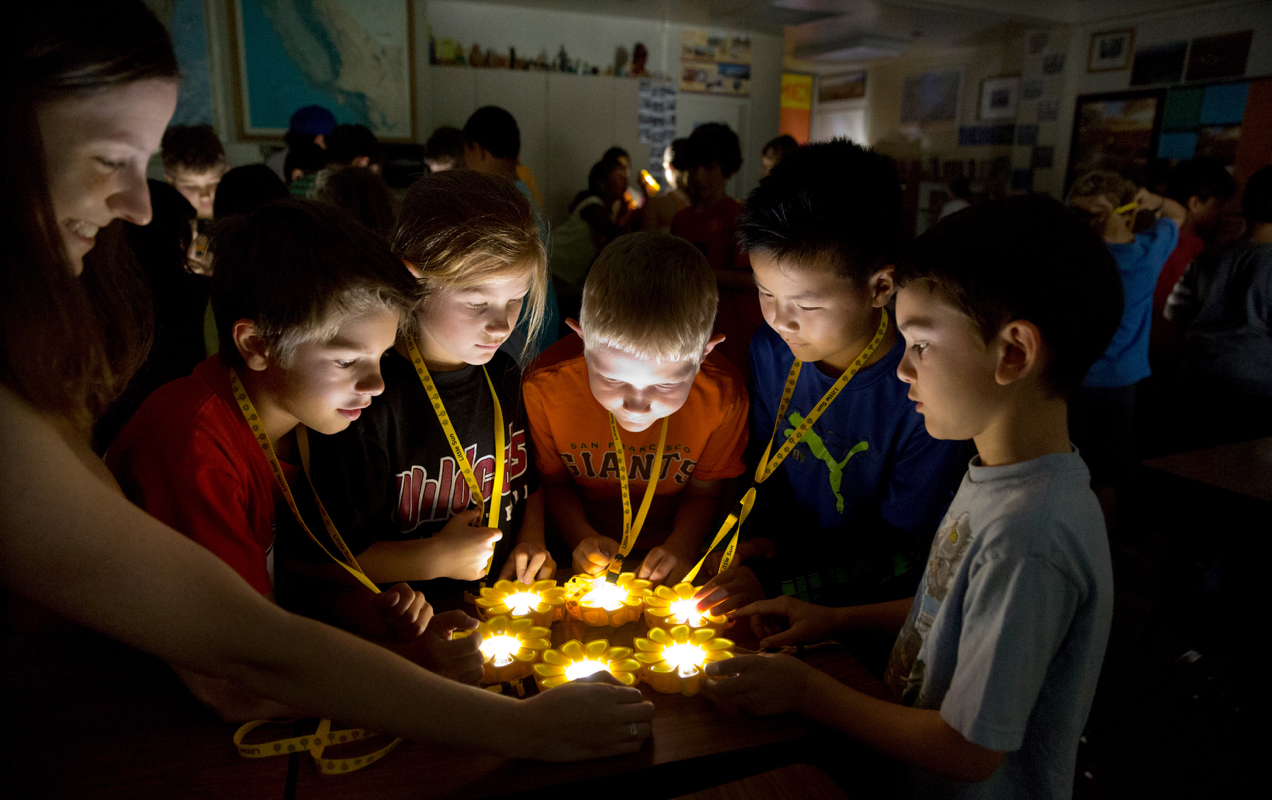 solar-powered lamp with kids gathered around