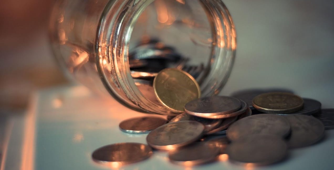 coins spilling out of a glass jar