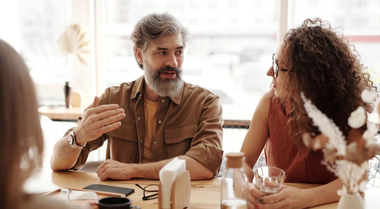 man explaining something to a woman at a table