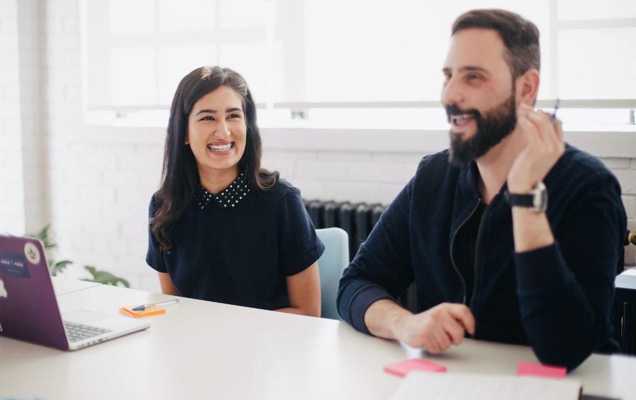 two team members working together around a laptop