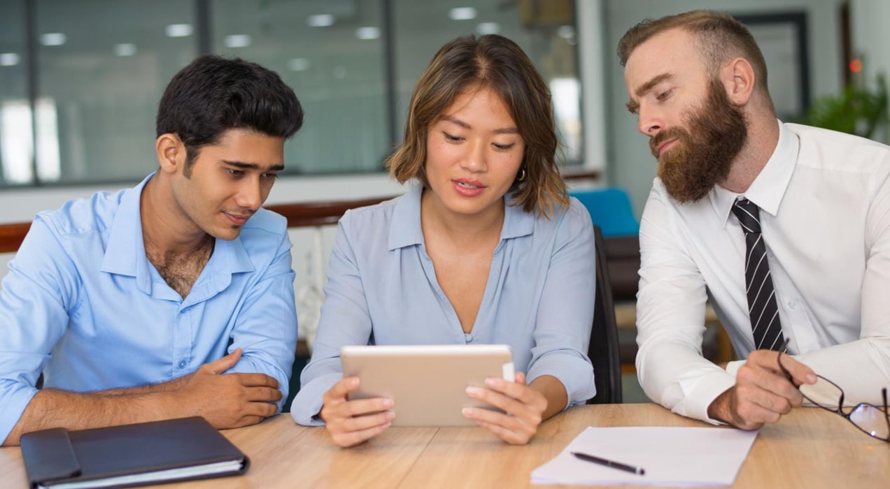 three team members working around a tablet