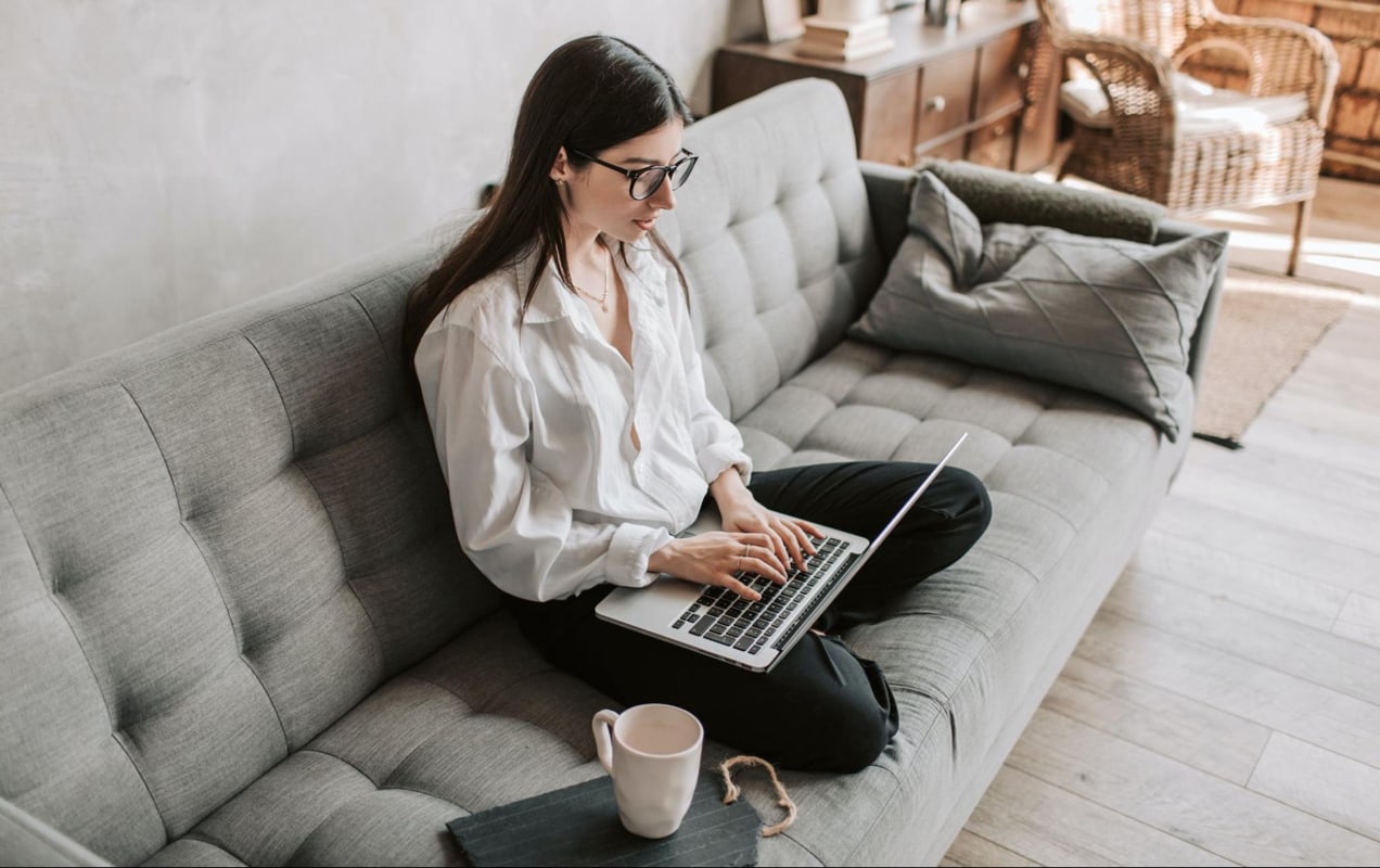 woman working on a couch with her laptop