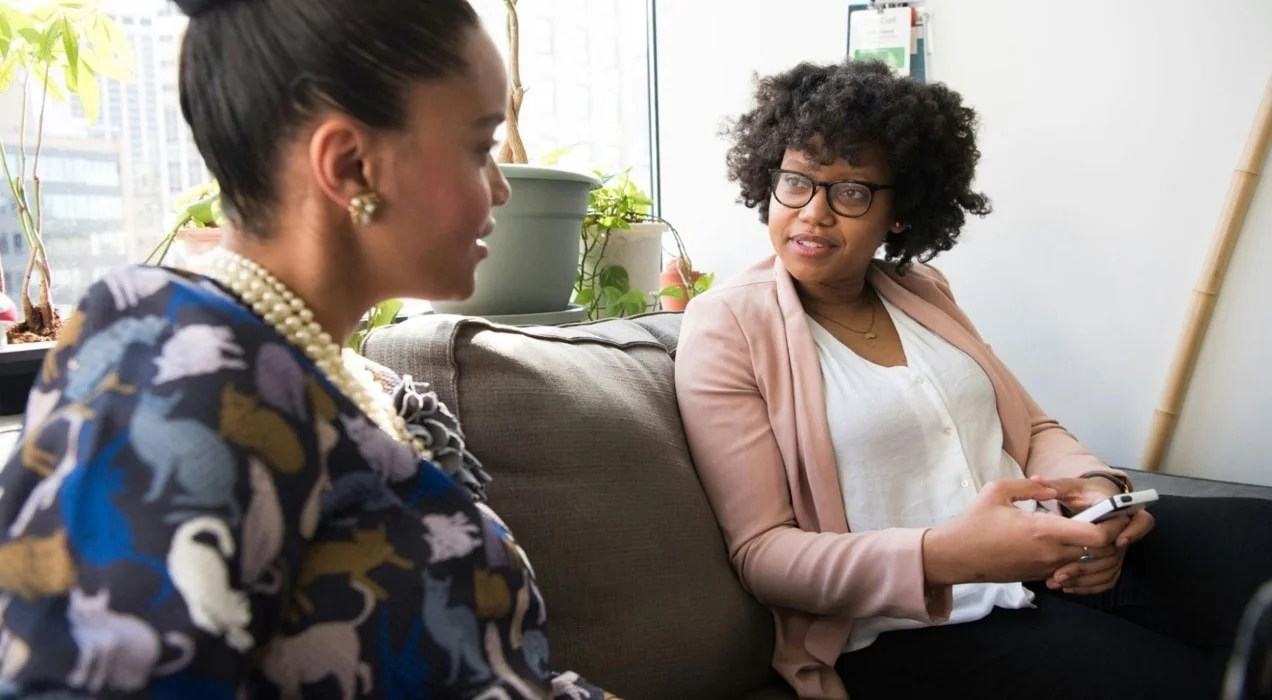 two women business owners chatting on a couch