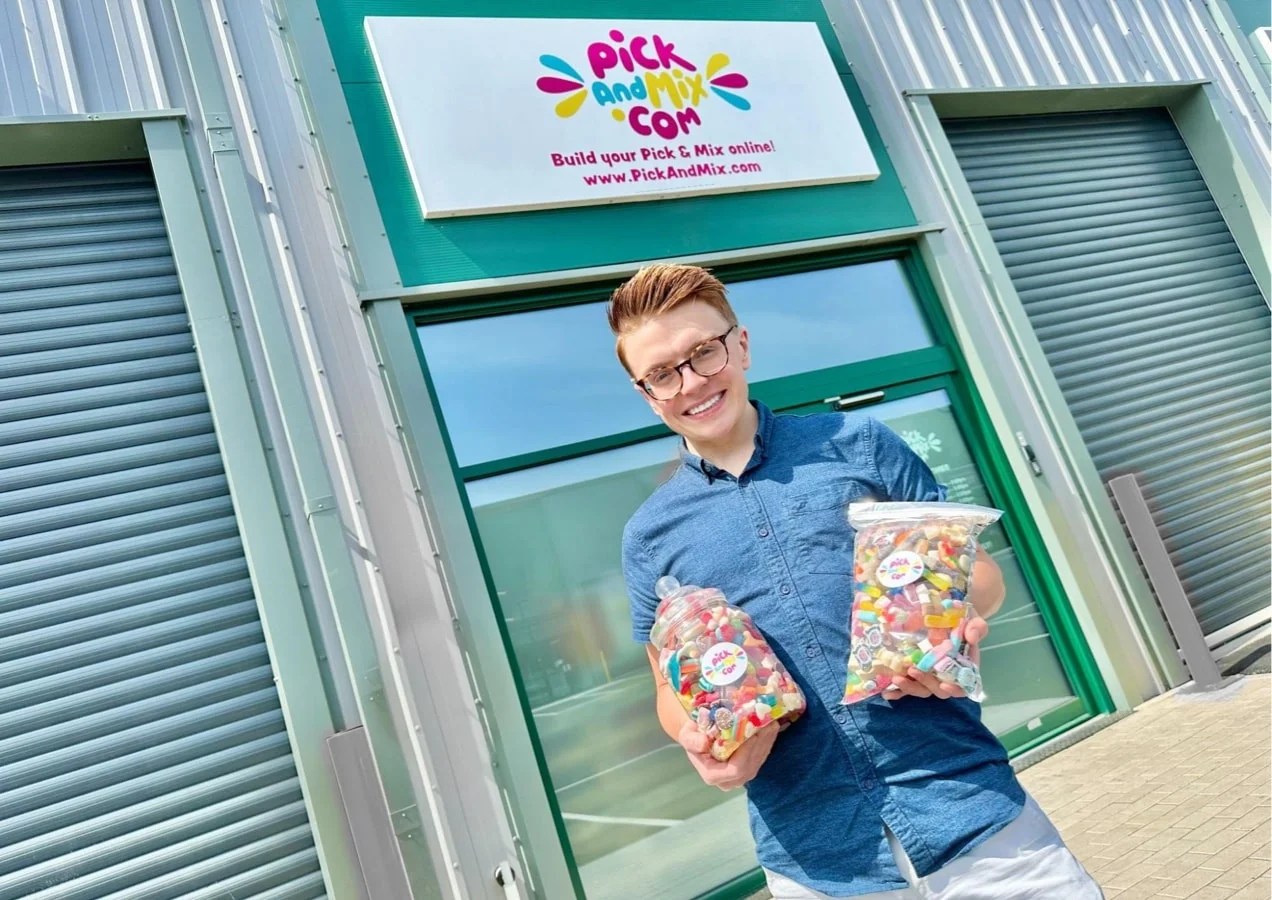 Members of the Pickandmix team standing in front of the building that holds the bags of candy