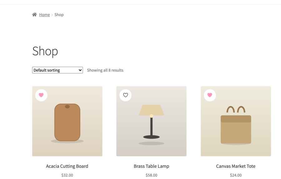 WooCommerce shop grid with an icon-only wishlist heart badge on the corner of each product image, two saved and one unsaved